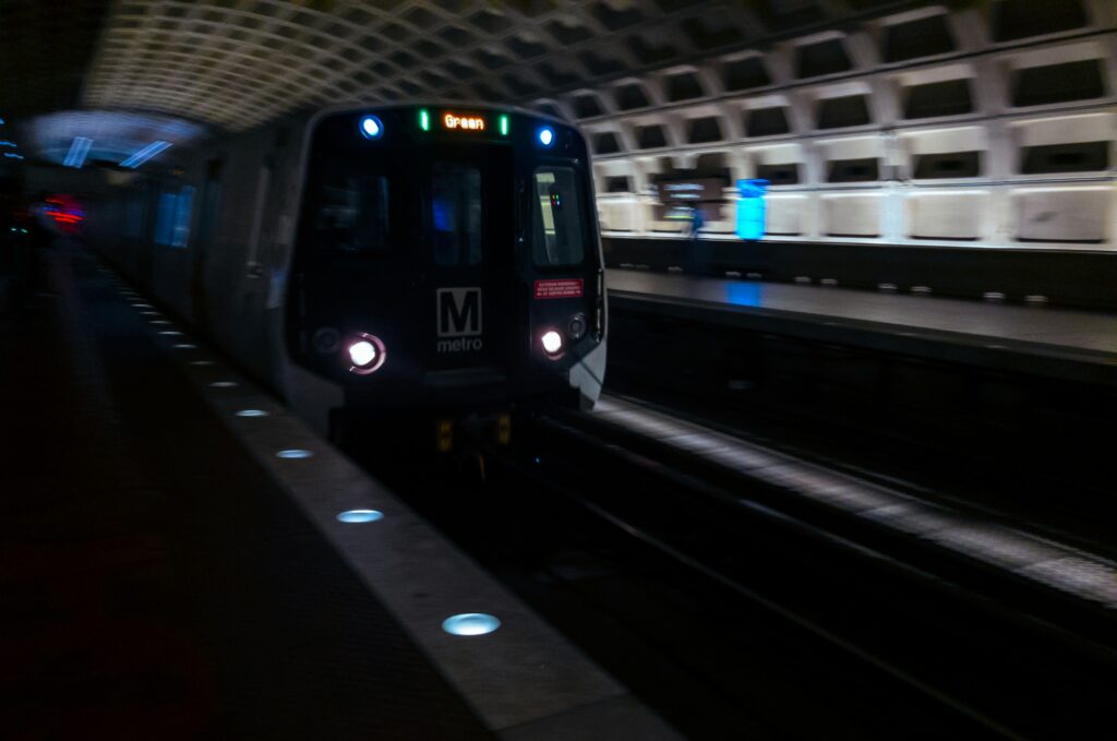 In a dark tunnel, a metro train is approaching.